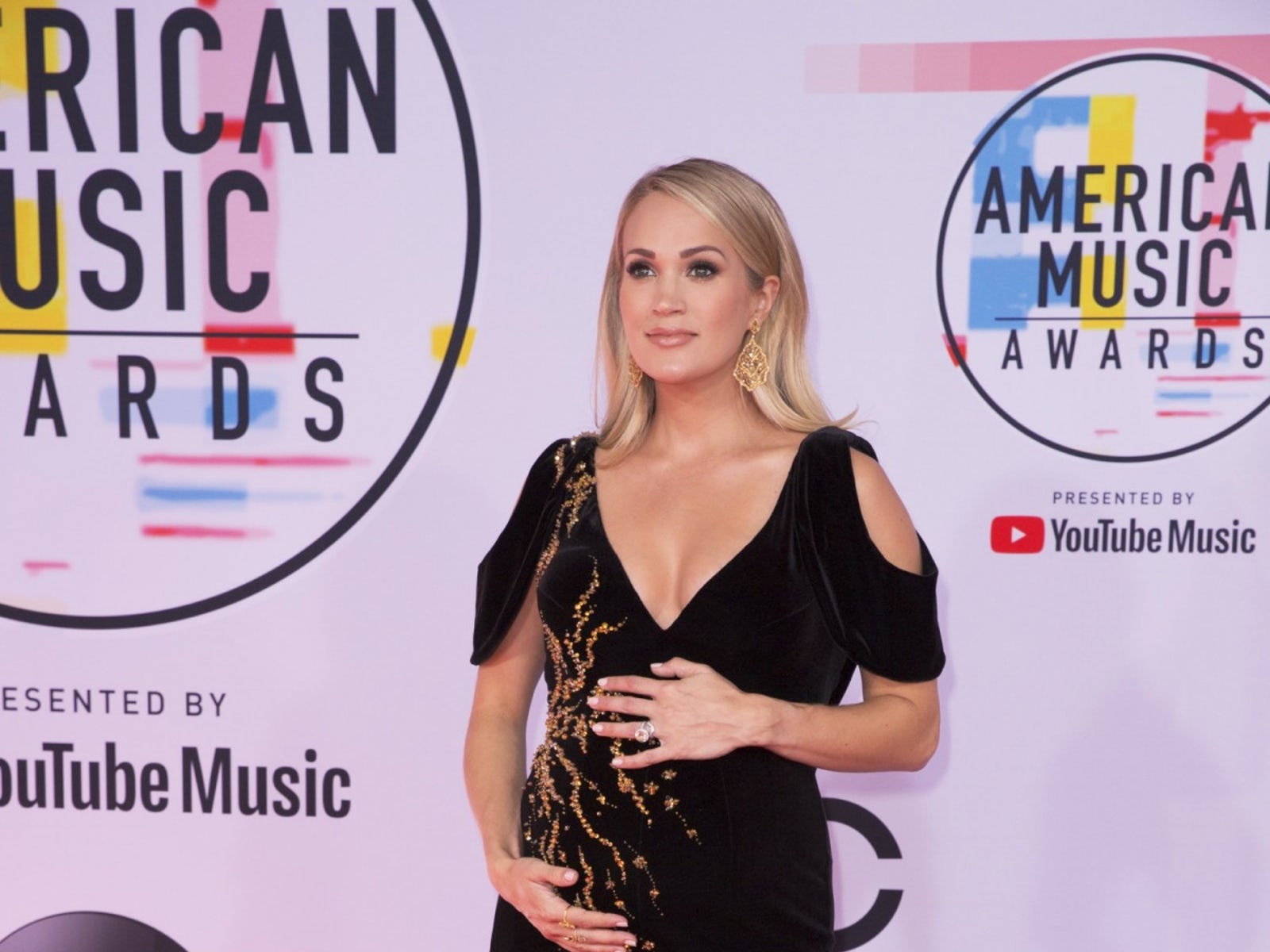 Carrie Underwood cradles baby bump at 2018 American Music Awards
